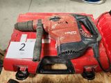 une perceuse rouge et un coffret rouge posés sur une table en bois