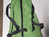 a green jacket with a black zipper on it on a table