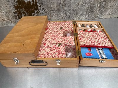 une boîte en bois à deux compartiments contenant du matériel de couture