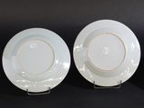 three white plates with gold rims sit on a black surface