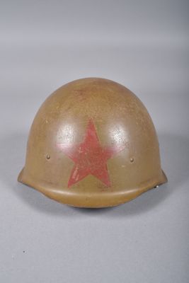 un casque orné d'une étoile rouge, posé sur une surface blanche