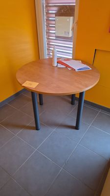 une petite table sur laquelle est posé un livre, dans une pièce jaune