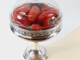 a glass bowl filled with tomatoes on top of a table