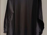 shirt hanging on a hanger on a white wall in a room