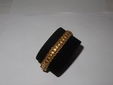 un gros plan d'une bague posée sur une surface blanche, avec un anneau en or
