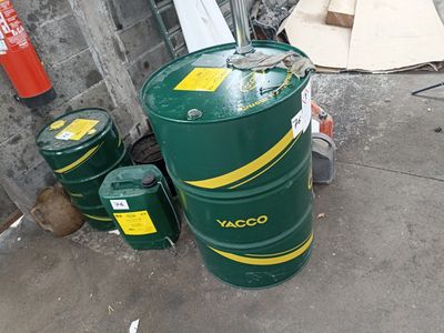 a large green barrel sitting next to two smaller green barrels