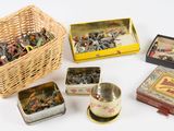 de nombreuses boîtes de jouets en fer blanc de toutes sortes dans un panier en osier