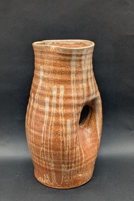 un vase marron troué sur fond noir