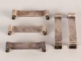 four pieces of silver metal on a white surface