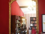 un miroir posé sur une cheminée dans une pièce aux murs rouges