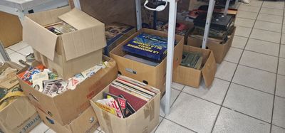 de nombreuses caisses de livres posées par terre dans une pièce