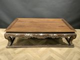 a wooden coffee table with ornate carvings on the top