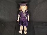 an old fashioned doll with a sailor outfit and hat on a black background