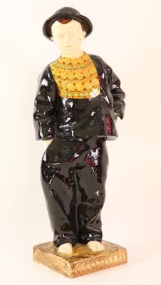 a figurine of a man wearing a hat and a black suit