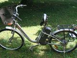 un vélo garé dans l'herbe, avec un panier à l'arrière
