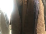 a lot of coats hanging on a rack in a room