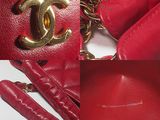 a red purse with a gold chain hanging from it