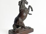 statue of a horse on its hind legs on a wooden base