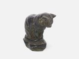 a statue of a cat sitting on top of a rock