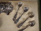 five spoons that are in a box on the table