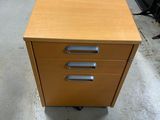 a wooden desk with three drawers on it in a room