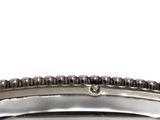 an antique silver plate with a beaded edge on a white background