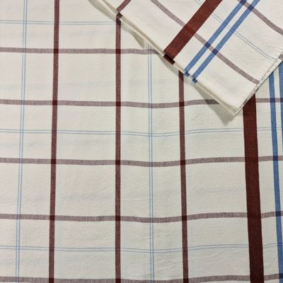 a close up of a white shirt with a brown and blue checkered pattern