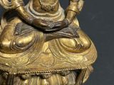 a gold statue of a person sitting on top of a table