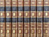 several old books are lined up on a shelf in a library