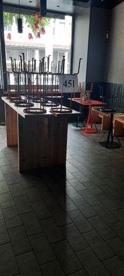 des tables et des chaises dans un restaurant doté de grandes baies vitrées et d'un sol carrelé