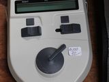 a white electronic device sitting on a table next to a bag