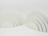 two white bookends are stacked on top of each other on a white surface