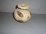 a small vase with a lid sitting on a table