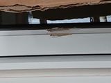 a piece of cardboard on the window sill of a house