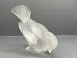 a glass bird that is sitting on top of a table