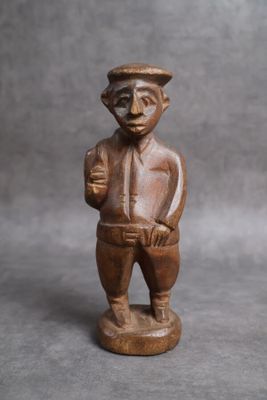 une vieille figurine en bois représentant un homme avec un chapeau sur la tête