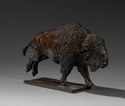 statue of a bison on a wooden base on a gray background