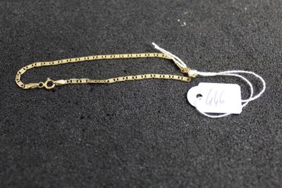 a close up of a gold chain with a tag on it