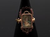 un gros plan d'une bague sur laquelle figure le portrait d'une femme