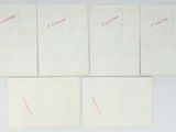 six cards with red writing on them are lined up on a white surface
