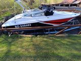 a boat that is sitting on the grass by the water