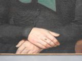 portrait of a man in a black coat with a green tie and a ring