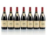 six bottles of wine lined up in a row on a white surface