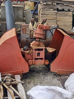 a red bulldozer that is sitting in a pile of wood