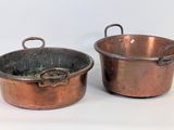 paire de casseroles en cuivre avec des poignées, sur fond blanc