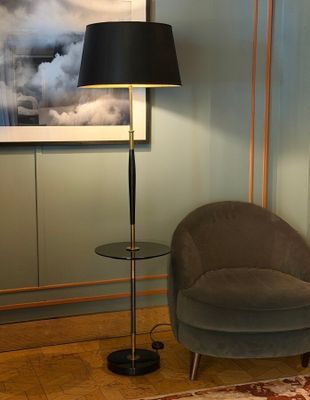 a chair and a lamp in a room with a picture on the wall
