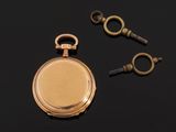 an antique gold pocket watch and two keys on a black surface