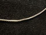 a diamond tennis chain on a black surface