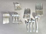 a lot of silver spoons and spoons on a table
