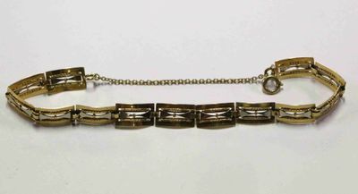 gros plan d'un bracelet en or sur une surface blanche